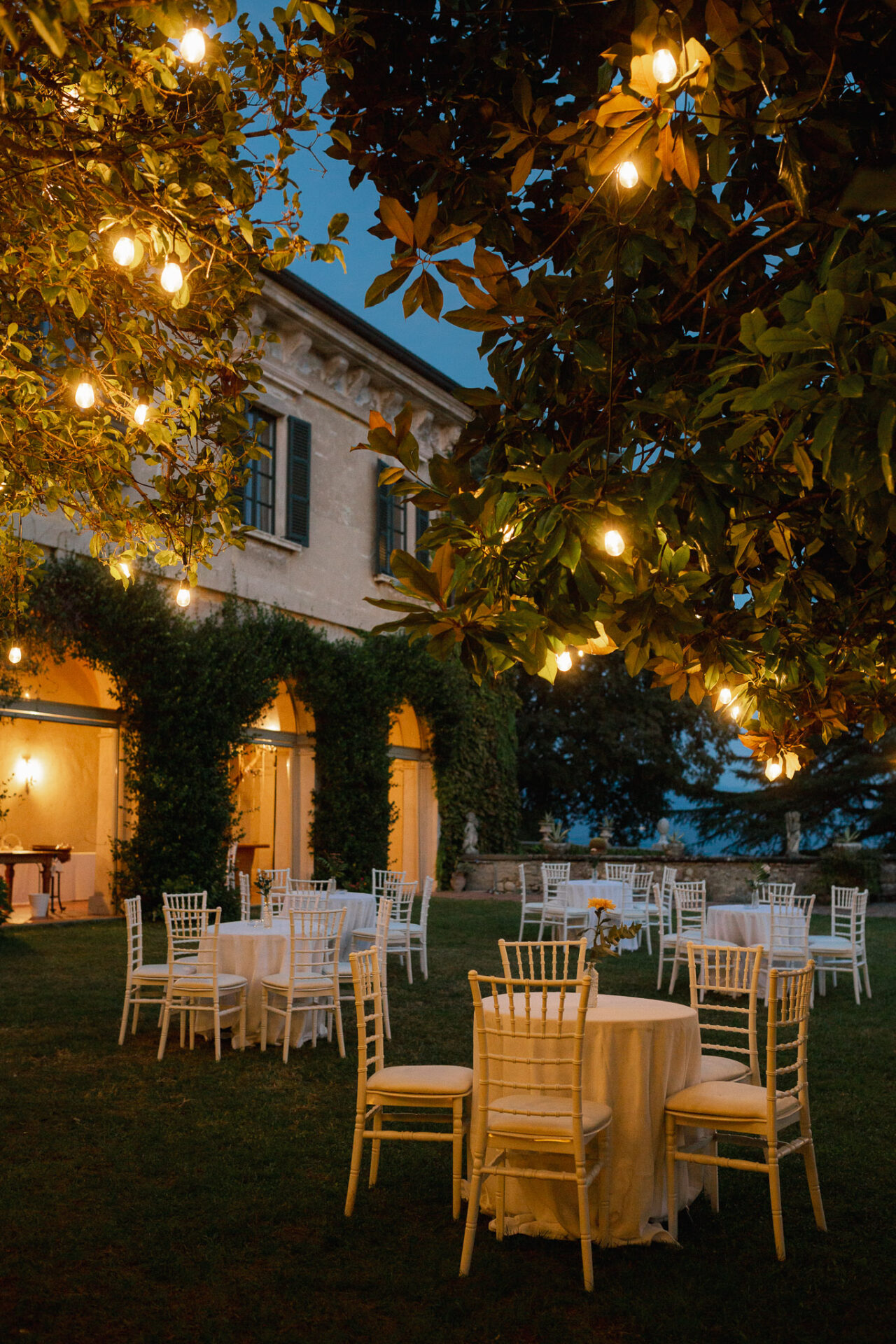 allestimento esterni villa cena villa monte rossa sedie chiavarine arcate edera tovaglie bianche lucine